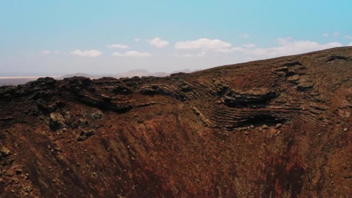 飞奥瑟一个巨大的火山口的斜坡。富埃特文图拉岛上的卡尔德隆洪多火山。红色干燥的贫瘠无生命的岩石土壤类似