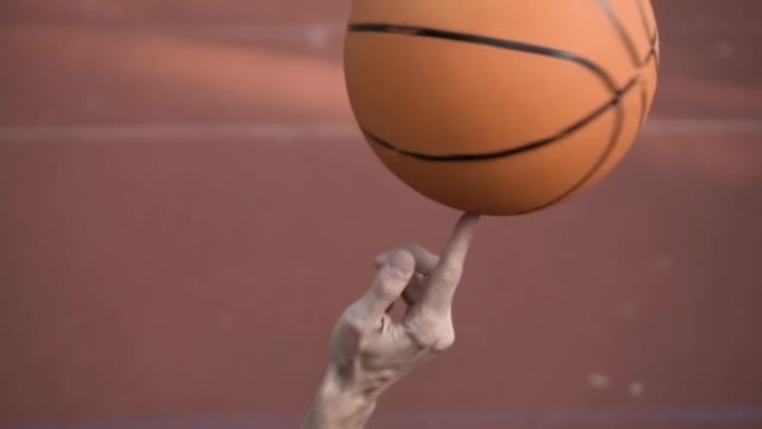 用手指旋转篮球的技巧尝试慢动作。运动生活方式。人人运动
