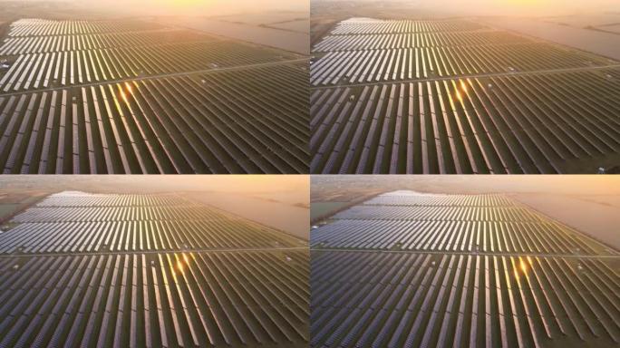 大型可持续发电厂的鸟瞰图，带有许多排的太阳能光伏板，用于在日落时产生清洁的电能。零排放概念的可再生电
