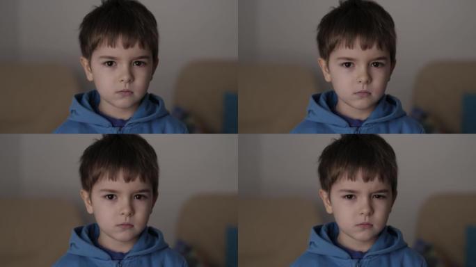 肖像悲伤的小男孩看着相机。思考好奇心的孩子在室内看着相机特写。沮丧的脸眼睛严肃沉思的孩子。严重的学生