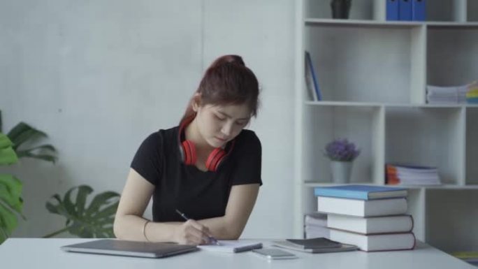 在线教育概念网格中戴着笔记本电脑和书籍的亚洲女性