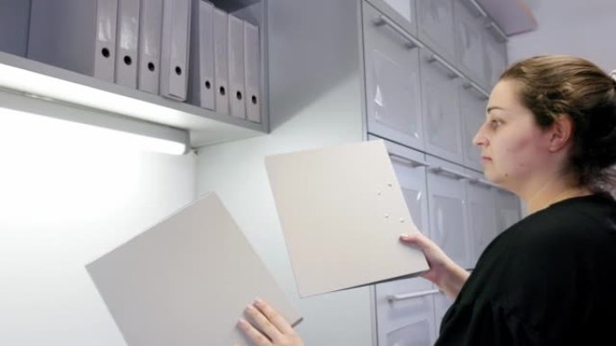 Woman putting files back in their place
