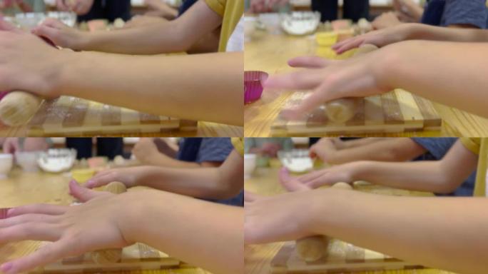使用木制rolling面杖准备馅饼面团的小孩的特写镜头