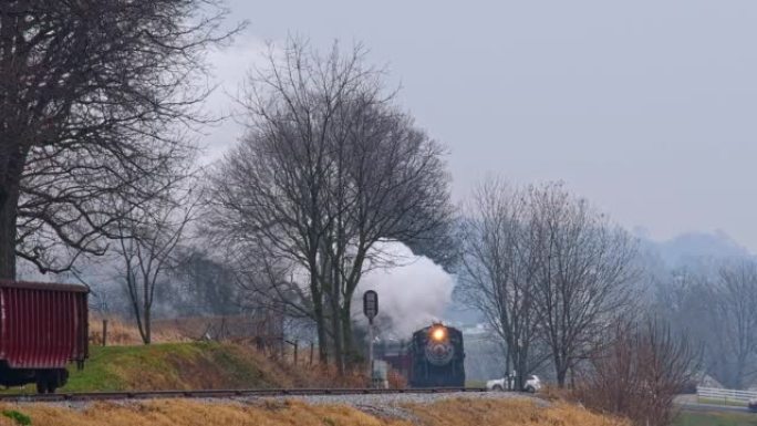 蒸汽旅客列车绕过弯道的长远视野，在冬天的日子里冒烟