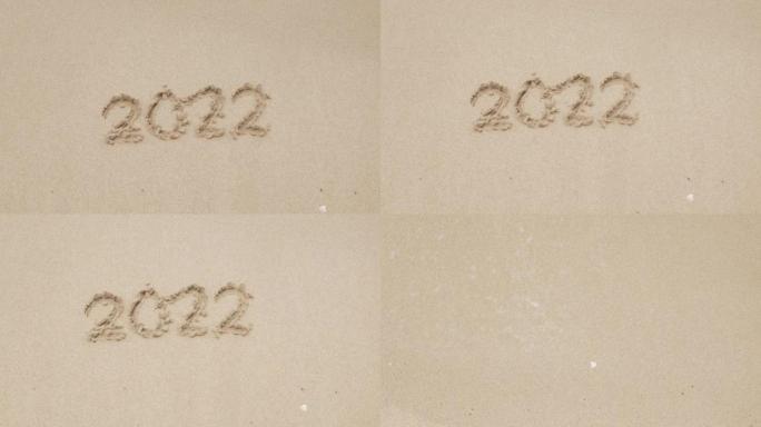 2022手写数字在沙滩上的新年快乐2023，海浪冲走数字手写在金色沙滩上的沙滩。再见2022