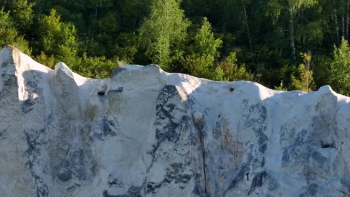 白色岩石在森林背景下的航拍录像。野生动物。白垩纪岩石。无人机镜头。特写
