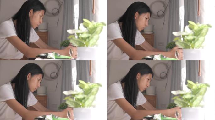 亚洲少女吃一些零食，通过智能手机在家窗口附近观看病毒视频或电影，生活方式概念。