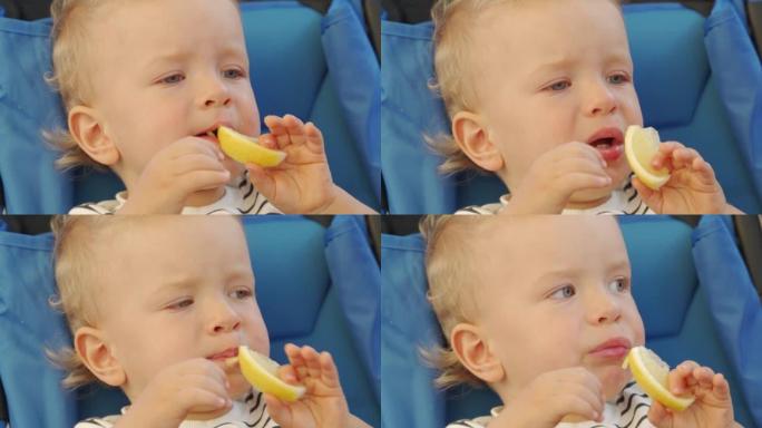 男婴第一次吃柠檬，拉傻脸。有趣的孩子第一次尝试柠檬。