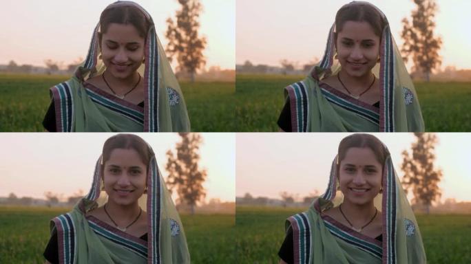 一个已婚的农村家庭主妇穿着传统的纱丽服在她的农田里耕作——小麦作物，印度农业