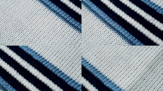 针织织物纹理上的蓝色和白色线条。特写细节毛衣面料背景。冬季时尚背景柔软羊毛纺织图案