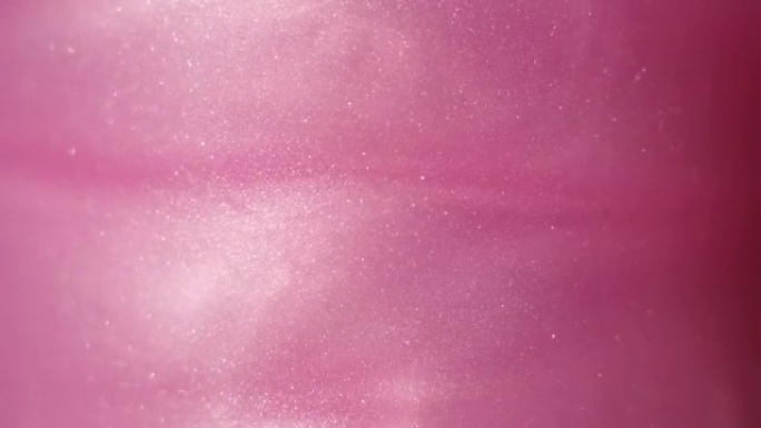 闪闪发光的抽象粉色背景。彩色流体在美丽的银云中旋转。闪光的灰尘在水中缓慢移动。惊人的抽象纹理背景。
