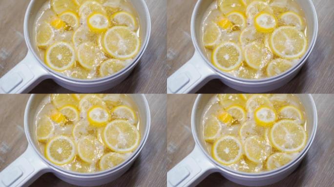 4k镜头在电锅中用沸腾的糖浆煮柠檬，用于制作蜂蜜柠檬苏打