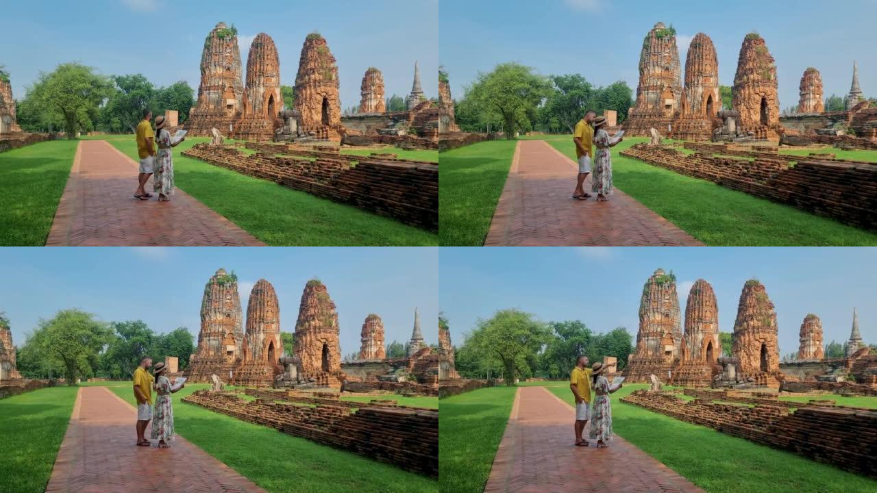泰国大城府 (Ayutthaya) 在Wat Mahathat，一对男女戴着帽子和旅游地图参观泰国大
