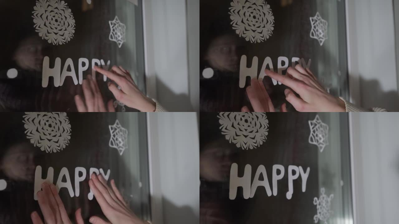 十几岁的女孩在窗户玻璃上贴纸字快乐