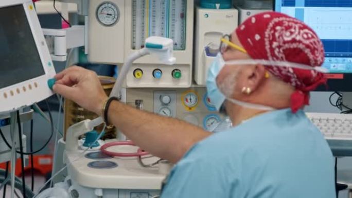 麻醉师在手术过程中看着患者的生命体征监测器