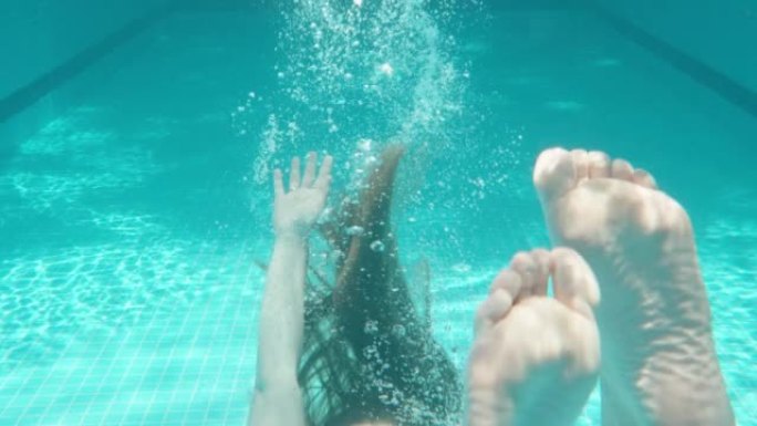 蓝色游泳池，水下拍摄，晴天。胖乎乎的女孩淹死在水里。慢动作
