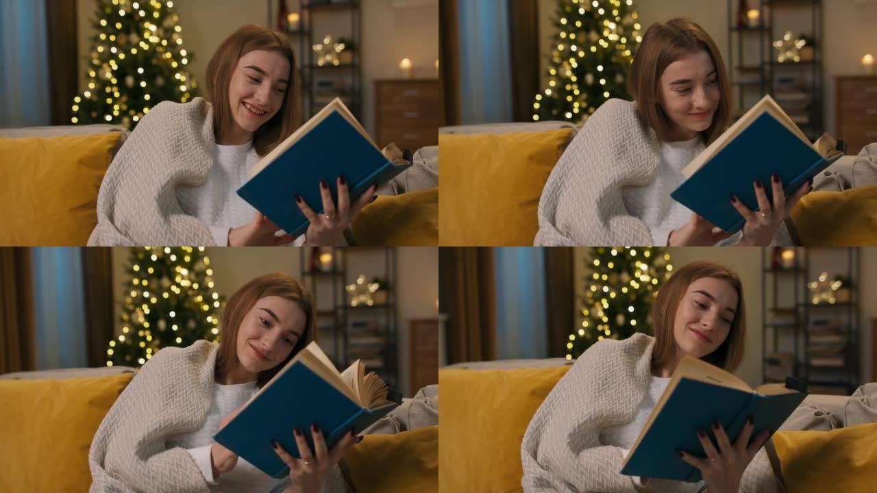 经过一天的辛苦工作，孤独的年轻女孩决定读书。她坐在客厅的沙发上，盖上毯子。她手里拿着蓝色装订的书，阅