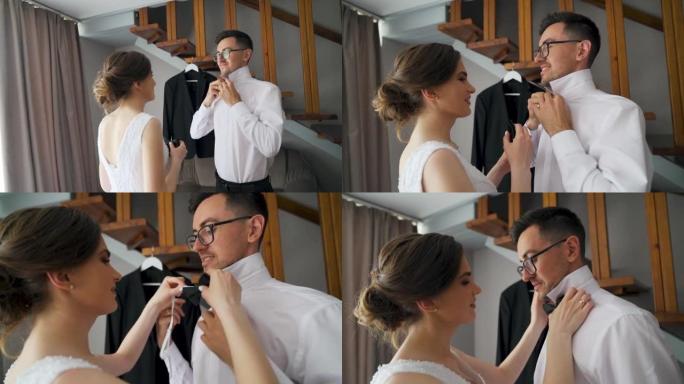 新娘帮助新郎穿好衣服，为婚礼做准备。慢动作