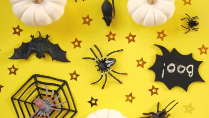 万圣节背景与黑色蝙蝠，蜘蛛，南瓜。现代假日设计。万圣节派对边框为黄色。平面布局，俯视图，复制空间。感