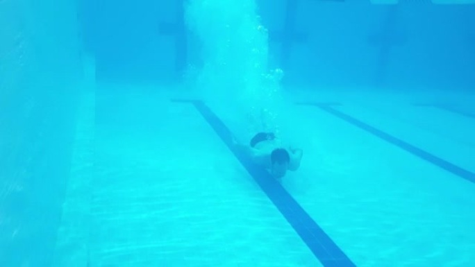 经过一天的艰苦工作，水下射击，一名男子在游泳池里潜水，放松和运动。