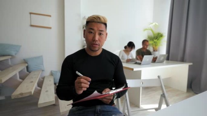 亚裔男子进行网上求职面试做笔记