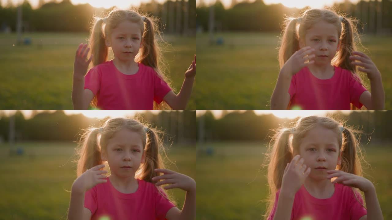 疲倦的小女孩在日落时在公园里挥手降温