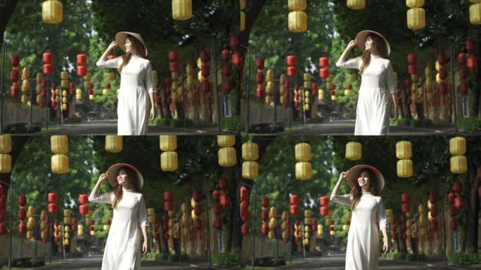 穿着传统服装和亚洲风格圆锥形帽子的4k越南女人在街上挂着传统的中国灯笼