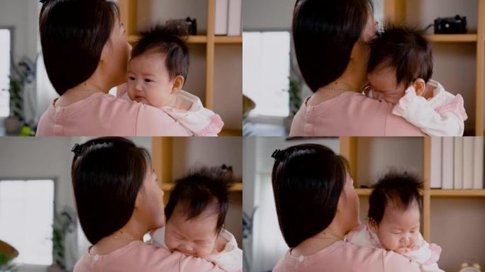 4K，亚洲妇女抱着她3个月大的女婴，在卧室里聊着让宝宝下午睡觉的好处。单身母亲正在照顾新生婴儿。
