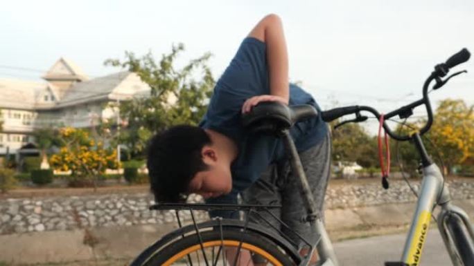 亚洲少年男孩修理自行车链条，当它在户外抛锚时。