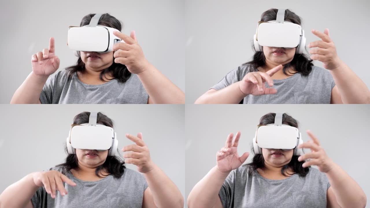 大型构建亚洲成年女性在灰色背景下使用虚拟现实，技术生活方式概念。