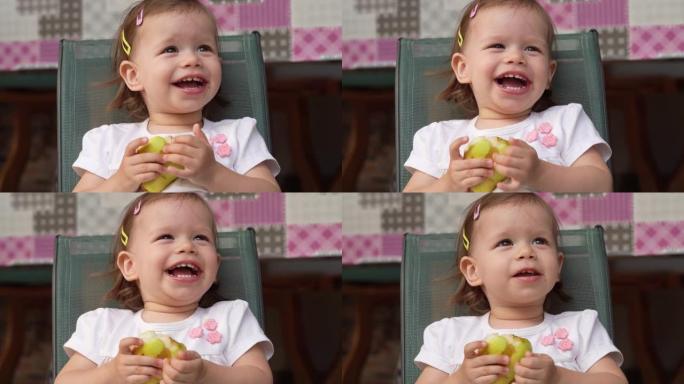 一个女孩小高加索蹒跚学步的孩子在户外复制空间吃梨