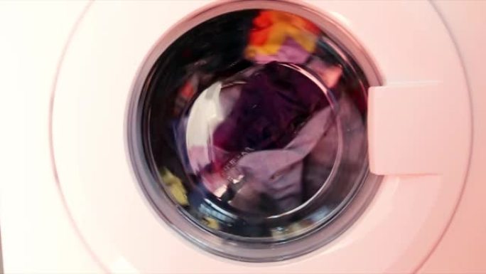 洗衣机洗彩色衣服。圆柱体旋转。没有人