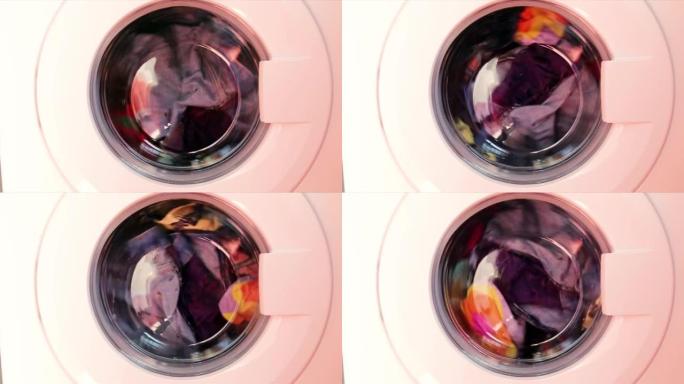 洗衣机洗彩色衣服。圆柱体旋转。没有人