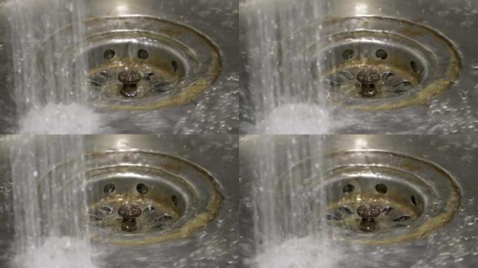水洒落在生锈的金属水槽上的特写镜头。