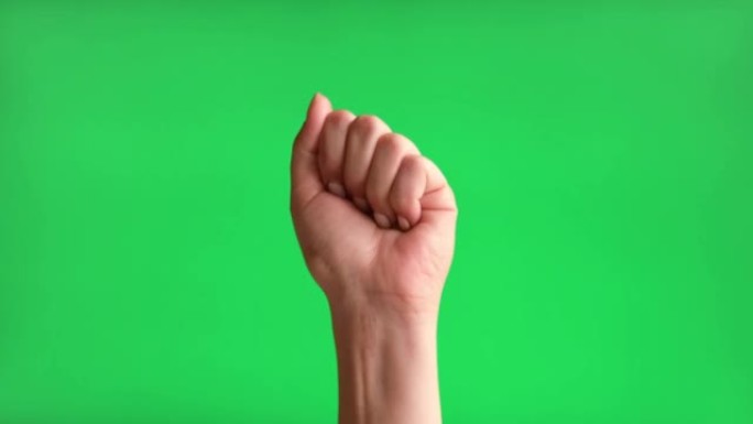 女性手与米色美甲制作崛起的标志与她的拳头。色度键绿屏背景。手势动作。4K镜头。关闭了。举起手，握紧拳
