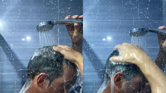 一个男人在浴室里用泡沫洗发露冲洗头发。一名年轻男子在淋浴时用慢动作从头发上去除肥皂的垂直视频。