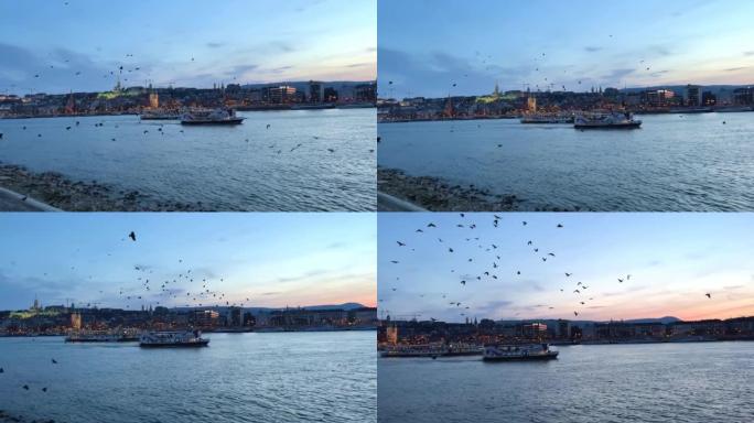 多瑙河在傍晚一艘船在远处的桥上飞着许多乌鸦和鸽子，在傍晚非常美丽，一切都在蓝色03.04.22匈牙利