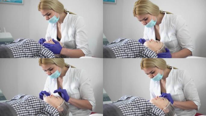 一位女性美容师用微电流抚平皱纹。恢复活力的面部护理。一个女孩在美容水疗中心接受提升治疗按摩。美容诊所
