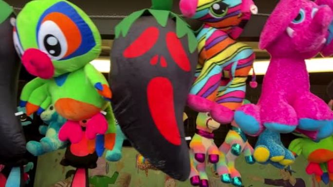 明亮的大玩具连续挂在游乐园的浣熊狗鹦鹉和其他非常鲜艳的颜色礼物给玩家