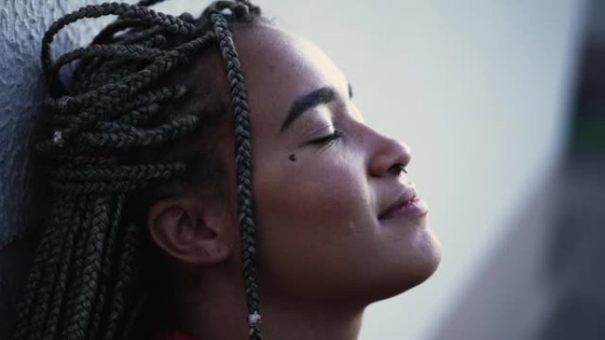 Meditative young woman eyes closed relaxing outsid