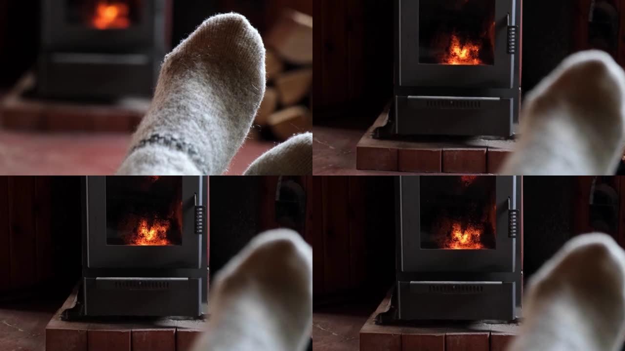 冬装羊毛袜在壁炉背景。女人在冬天或秋天的晚上坐在家里放松和热身。冬季和寒冷天气概念。圣诞夜。
