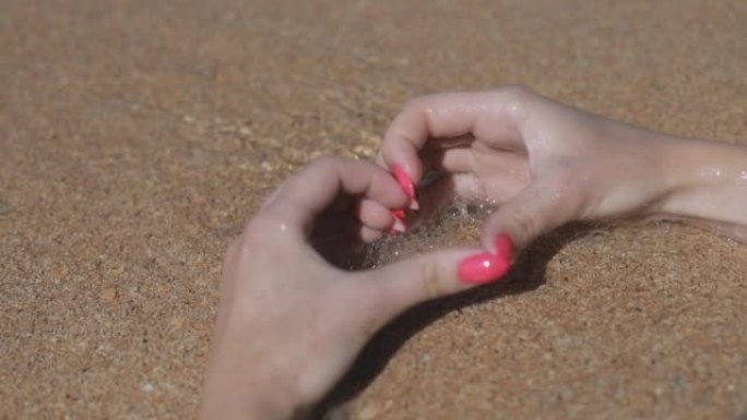 海边沙滩上女孩手中的心脏特写，度假概念