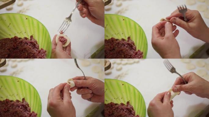女性的手用叉子从一个大碗中挑肉末，然后将饺子的馅料放入面团中。