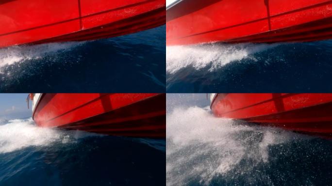 摩托艇，底角视图。海浪在快艇的侧面高速撞击。地中海绿松石水的飞溅。船的红色底部在水面上滑行。