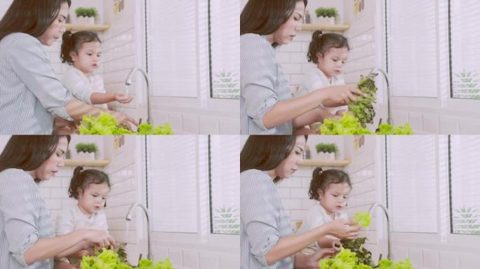 亚洲妈妈教女儿在厨房里清洁和切片蔬菜。家庭概念