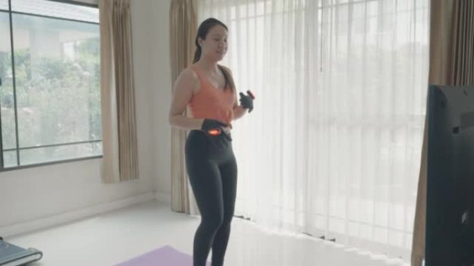 年轻女子在家锻炼时玩虚拟技术跑步