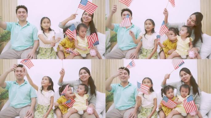 7月4日，独立日，美国的亚洲家庭举着美国国旗在客厅里飘扬。独立日概念。