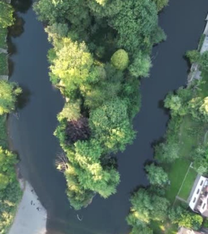 垂直视频，空中无人机俯视流经公共公园的大型内城河流。塞文河