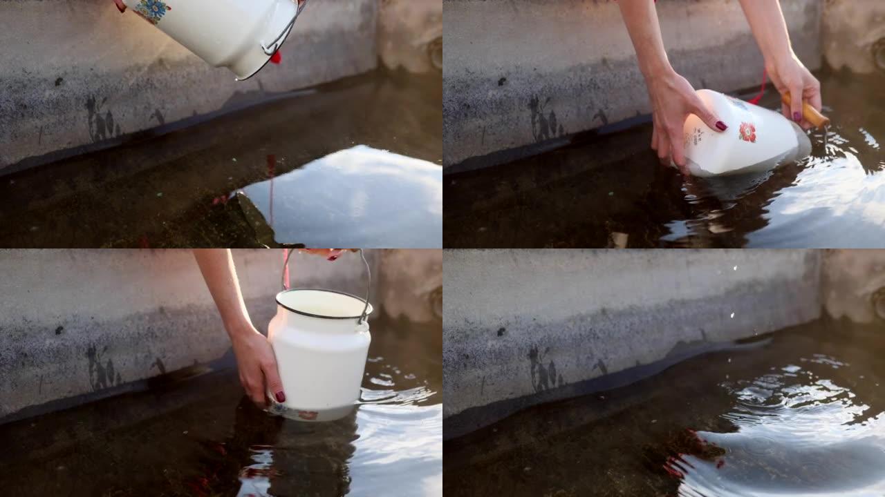 女人的手从装有水的容器里用罐舀水。