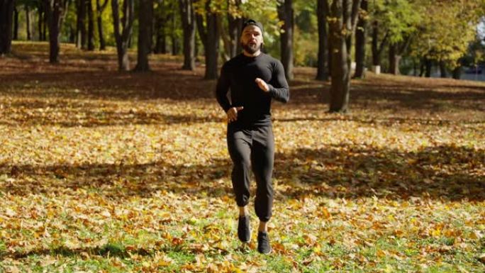 男人做运动，原地慢跑，慢动作。秋季户外活动